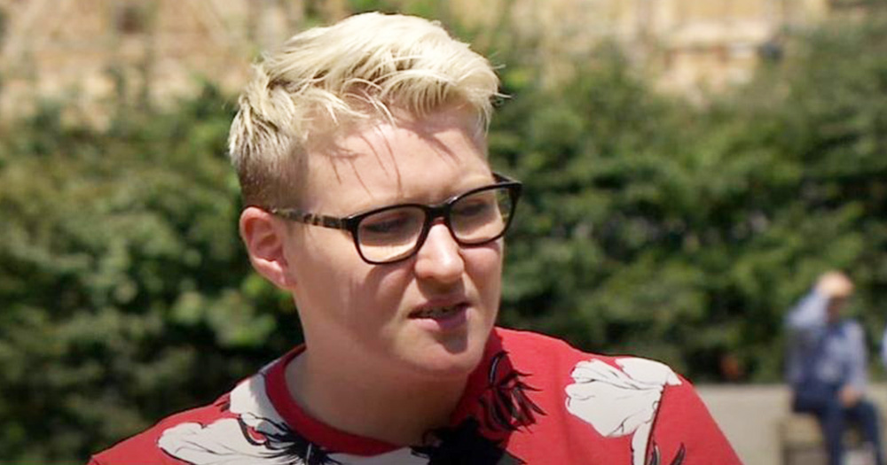 Vicky Trimble - a young woman with short blonde hair and glasses sits in a park