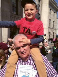 Noel Whelan with his young son on his shoulders standing on O'Connell Street