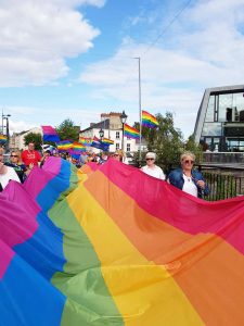 A group of women carry a massive Pride flag through Thurles