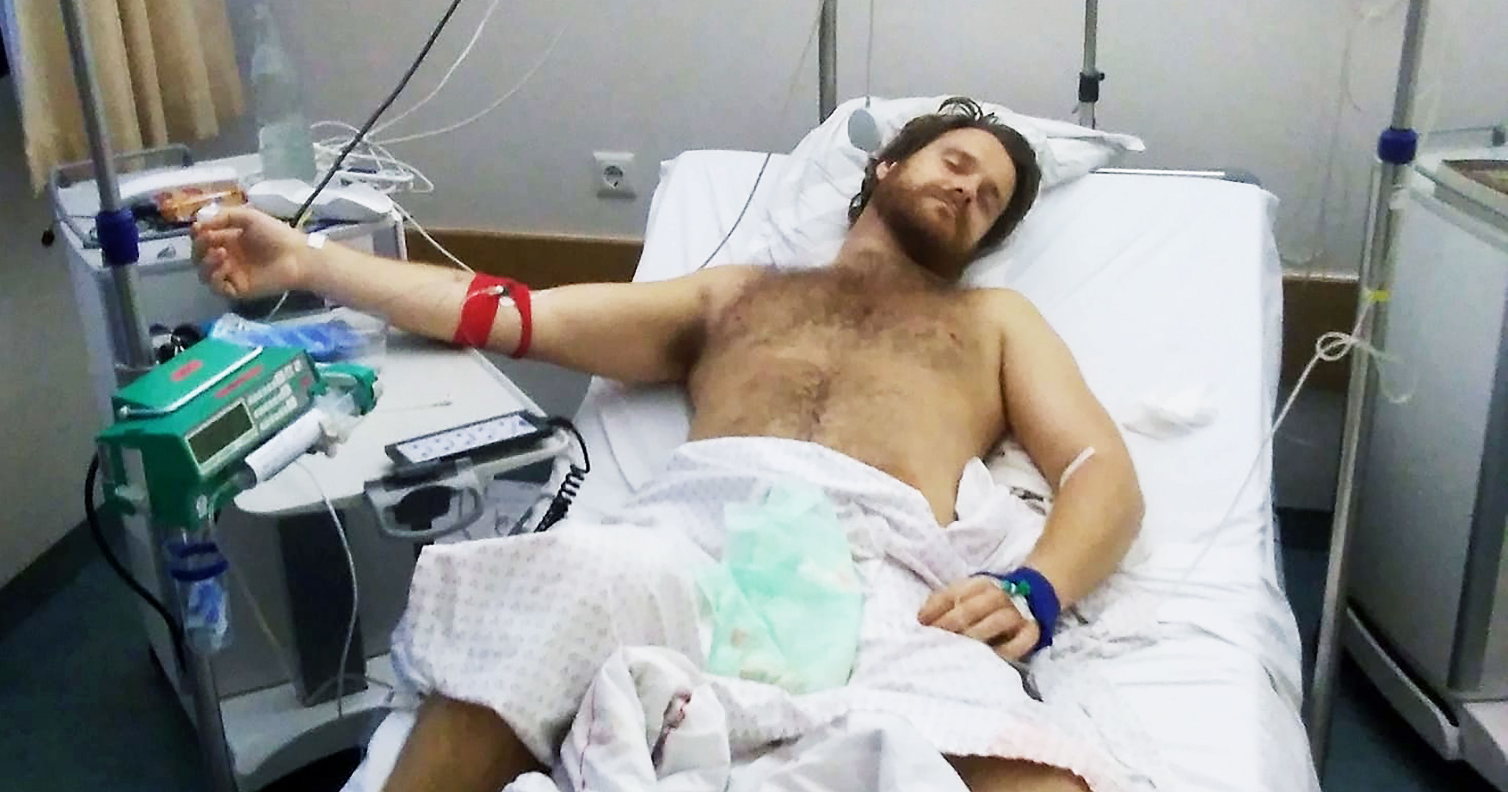 A man in a hospital bed with medical equipment after being admitted for complications due to the use of an erection enhancing drug