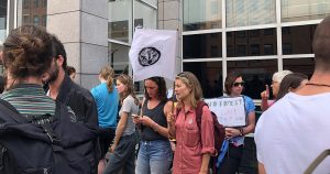 Woman waving the flag at the Extinction Rebellion protest of the Amazon burning