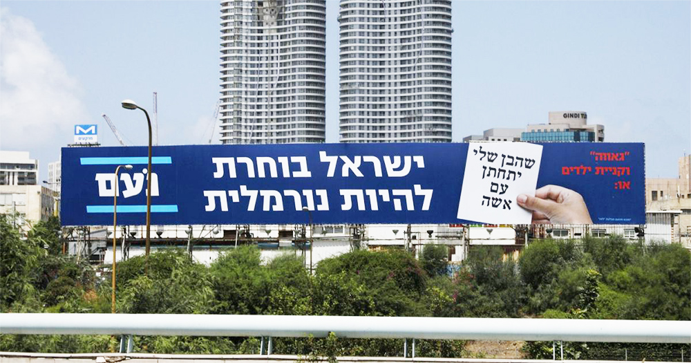 Political ads with Hebrew writing on a billboard by a highway, skyscrapers behind