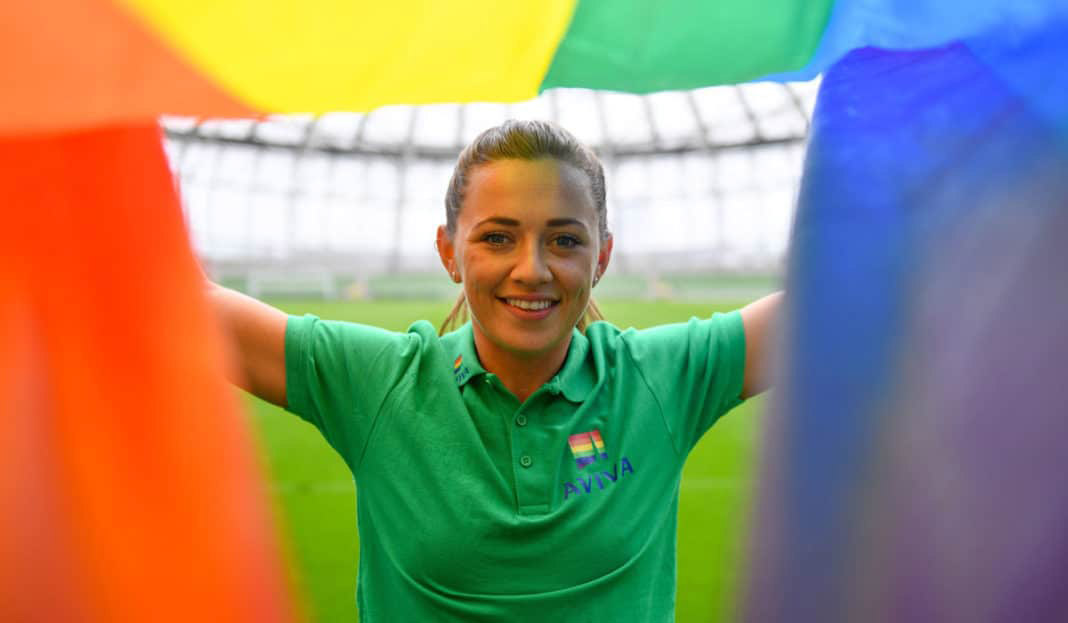 Katie McCabe holding up a rainbow pride flag in Aviva stadium