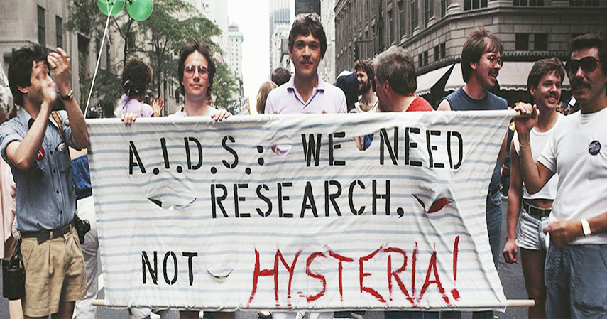 Activists in New York in the 1980s hold a banner reading "AIDS we need research not hysteria"