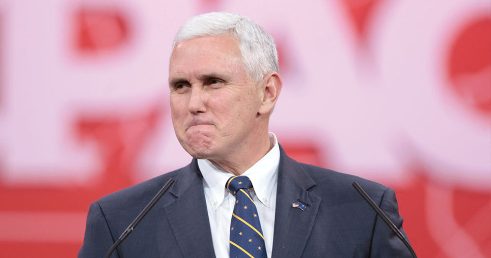 Mike Pence looking bitter in front of red backdrop.