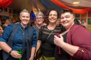Four smiling women at a party