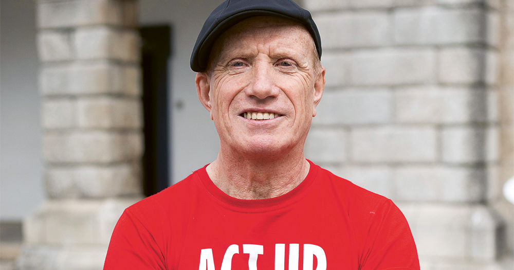 Close up of ACT UP Cork activist Will Kennedy wearing a red t-shirt and a hat