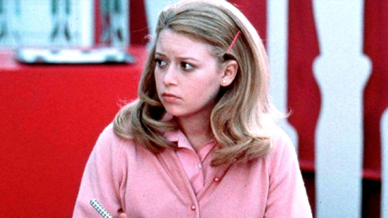 DIY Halloween costume ideas:Young blond girl wearing a pink shirt and cardigan with long blond hair looks to her right