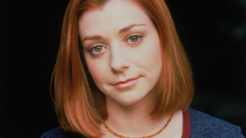 DIY Halloween costume ideas:Young woman with shoulder length red hair wearing a necklace looks into the camera