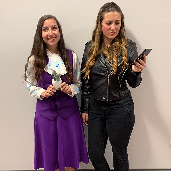 Two women dressed up in good Janet and Bad Janet Halloween costumes