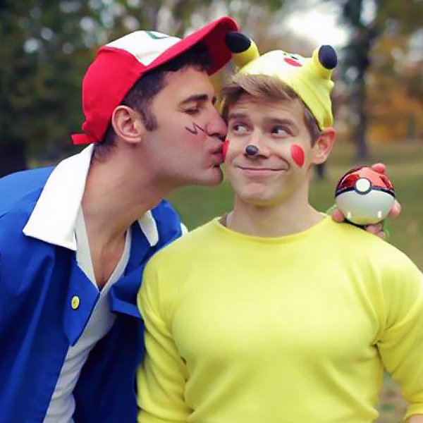 Two men dressed as Ash and Pikachu, one is kissing the other one