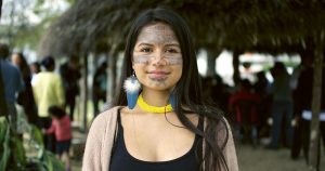 A young Ecuadorian climate crisis activist with tribal designs on her face