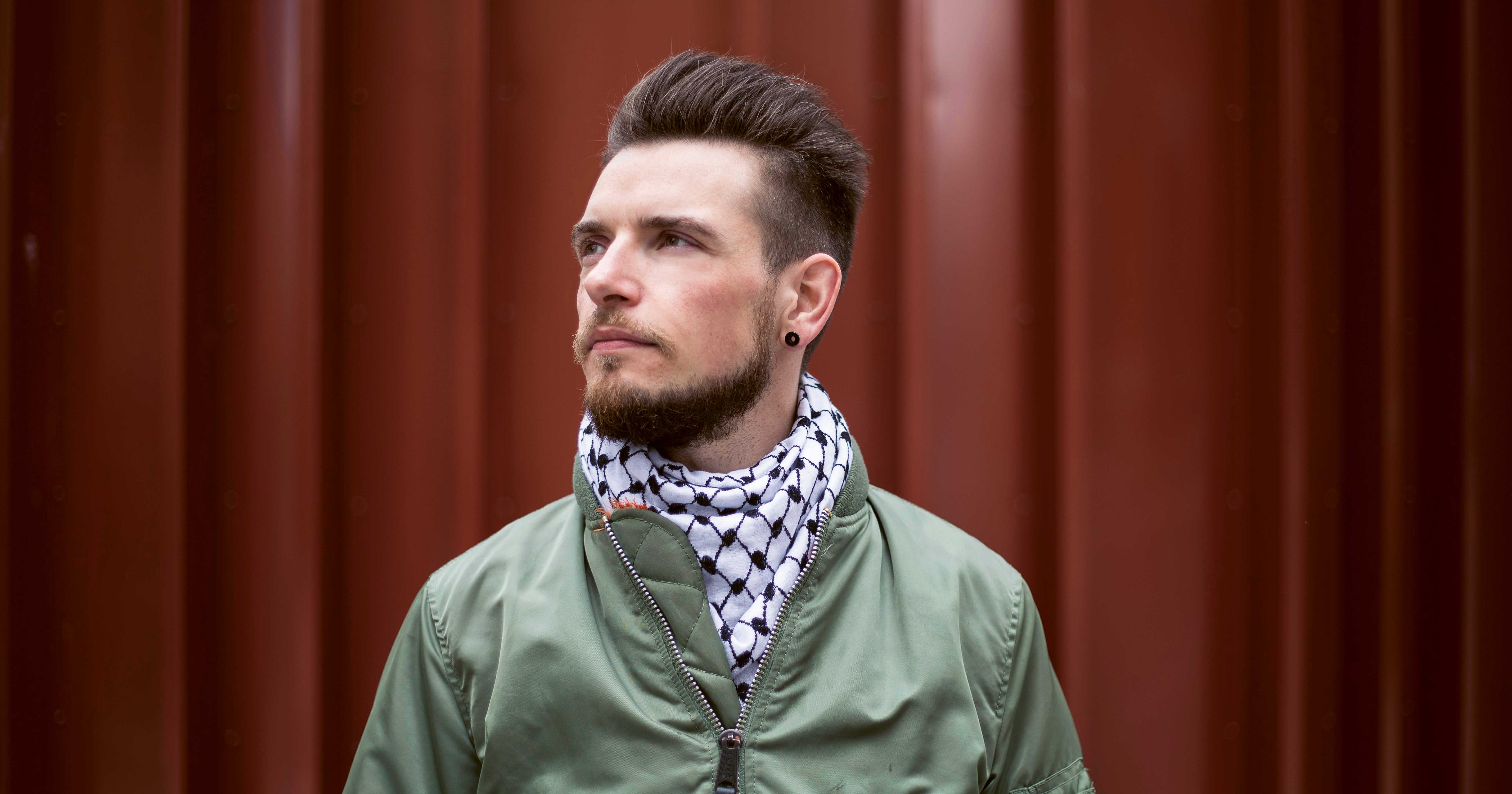 A man wearing a green jacket and scarf. In this interview, an HIV positive man talks about U=U and stigma