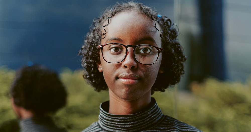 A young black girl who is a climate crisis activist posing outdoors