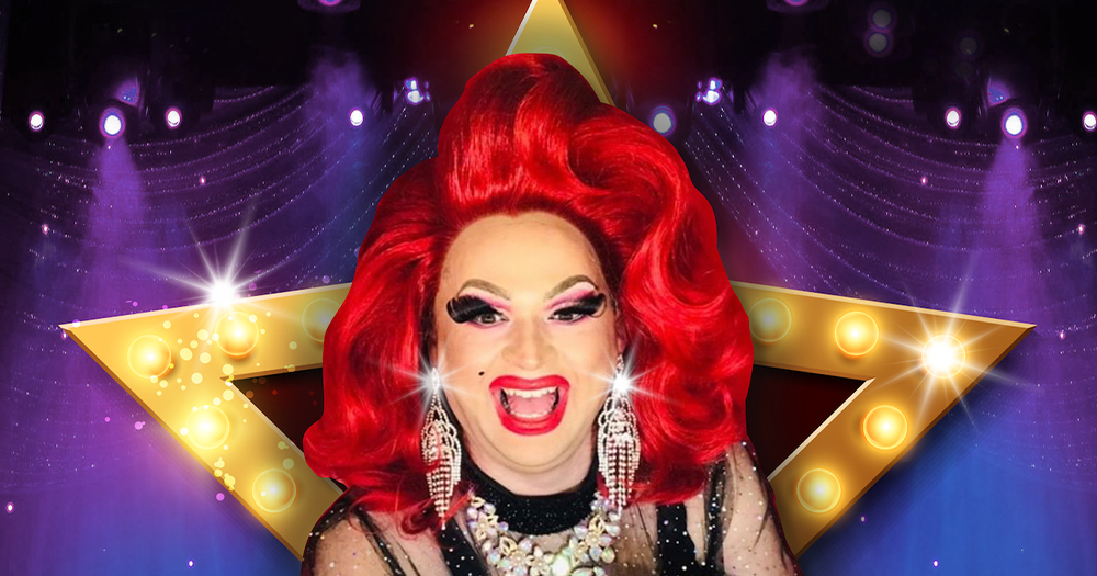 A smiling drag queen in front of a star made of lights