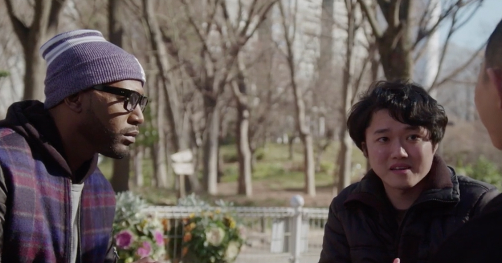 A black man speaks to two gay asians in a public park in Japan