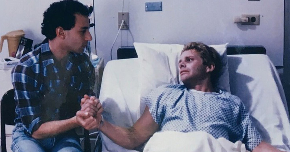 David holding Robert's hand while in a hospital, a scene from Buddies, playing in the IFI