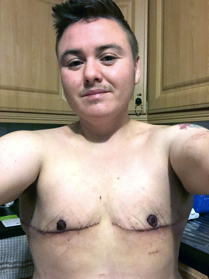 Young trans man taking a shirtless selfie