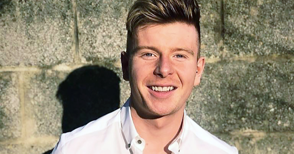 Close-up of Mr Gay Ireland 2020 Lorcan Mc Auliffe smiling, wearing a white t-shirt