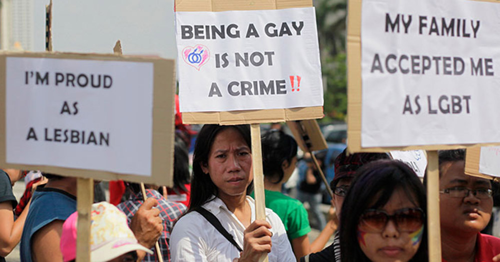 Malaysian LGBT+ community protesting against Malaysian authorities restrictive regime, signs held read Being gay is not a crime