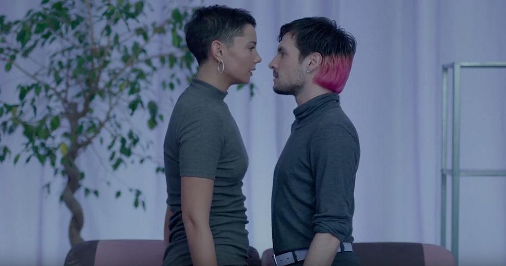 Two dancers inches apart, wearing grey coloured clothes in the 100 Ways music video