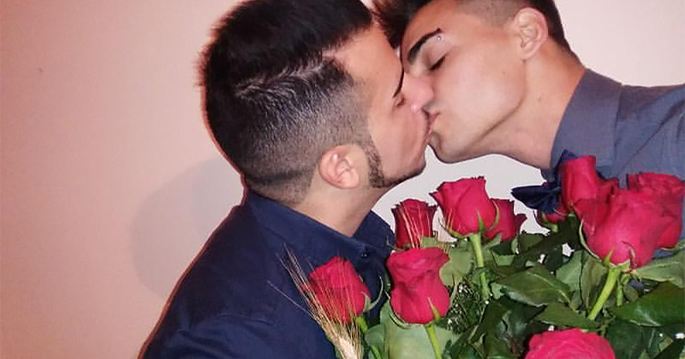 two men kissing while holding roses - this is the photo that won the "most beautiful kiss" contest