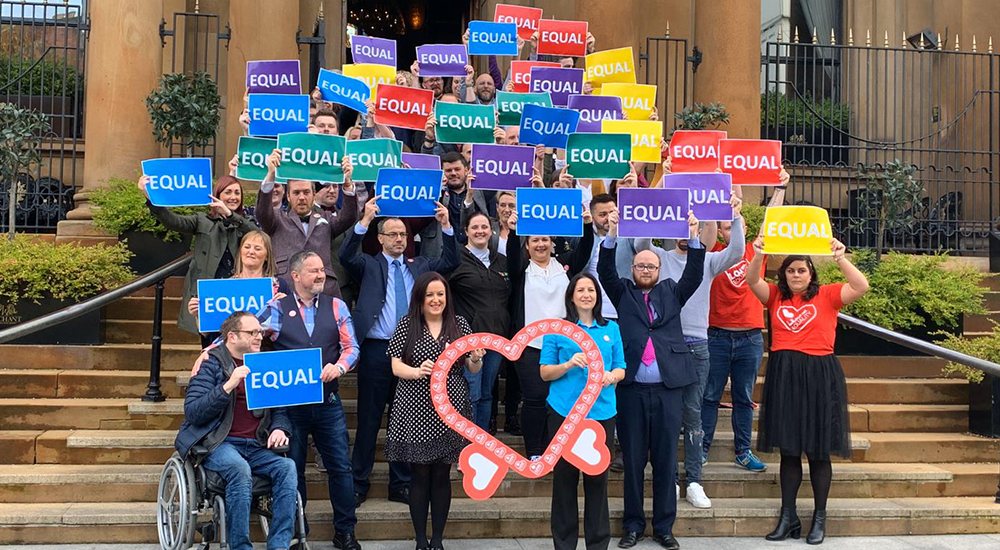 People holding EQUAL signs after same sex weddings in Northern Ireland became legal
