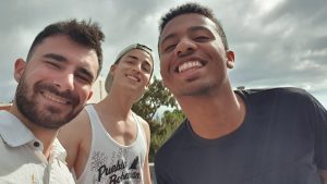 A group of three young men larking about in a park