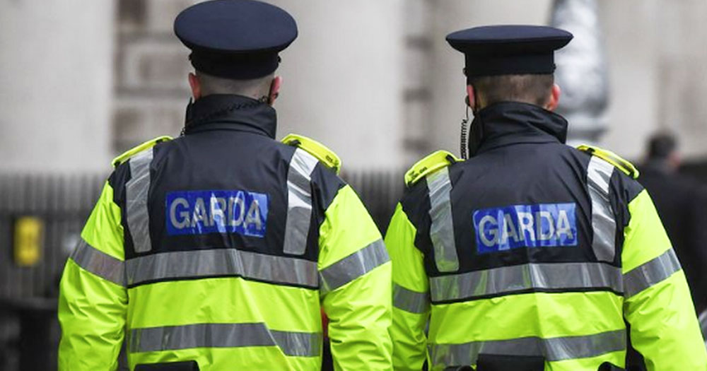 Two guards in high vis vests seen from behind on a city street