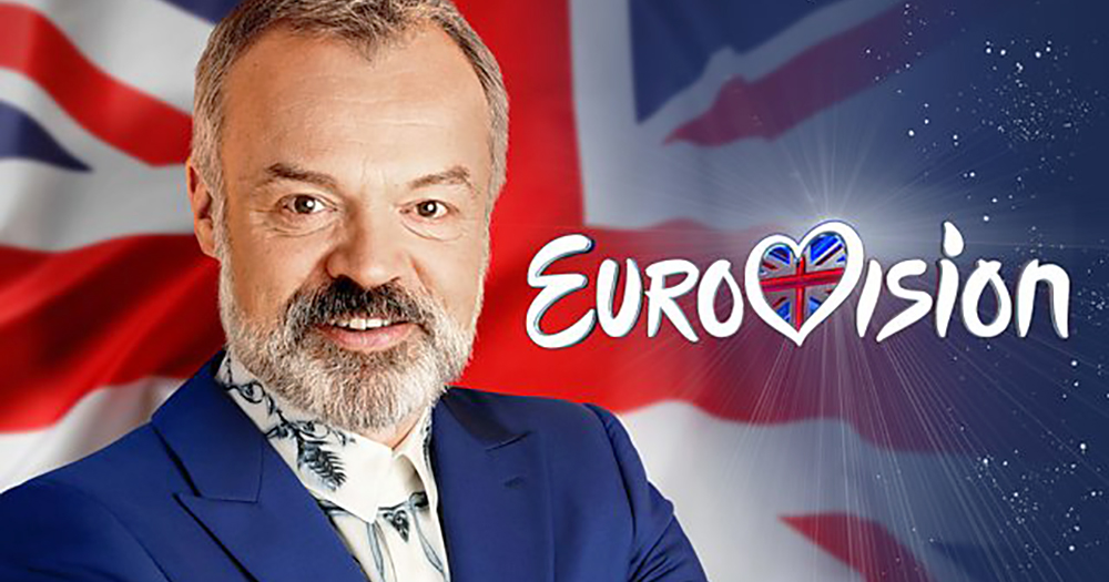Graham Norton standing in front of British flag beside words Eurovision, he has recently been announced as host of Eurovision: Come Together