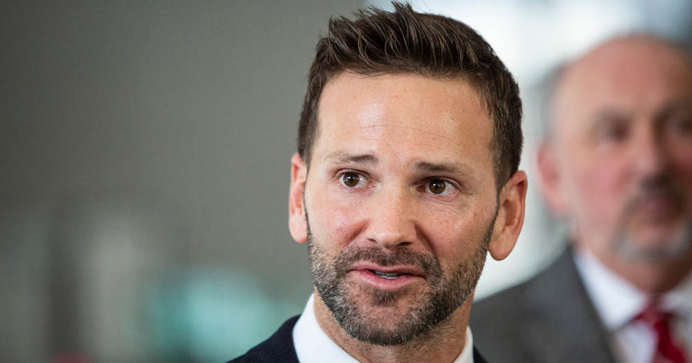 Aaron Schock in a black suit with stubble.