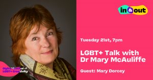 A smiling middle sagged woman with short red hair wearing a scarf