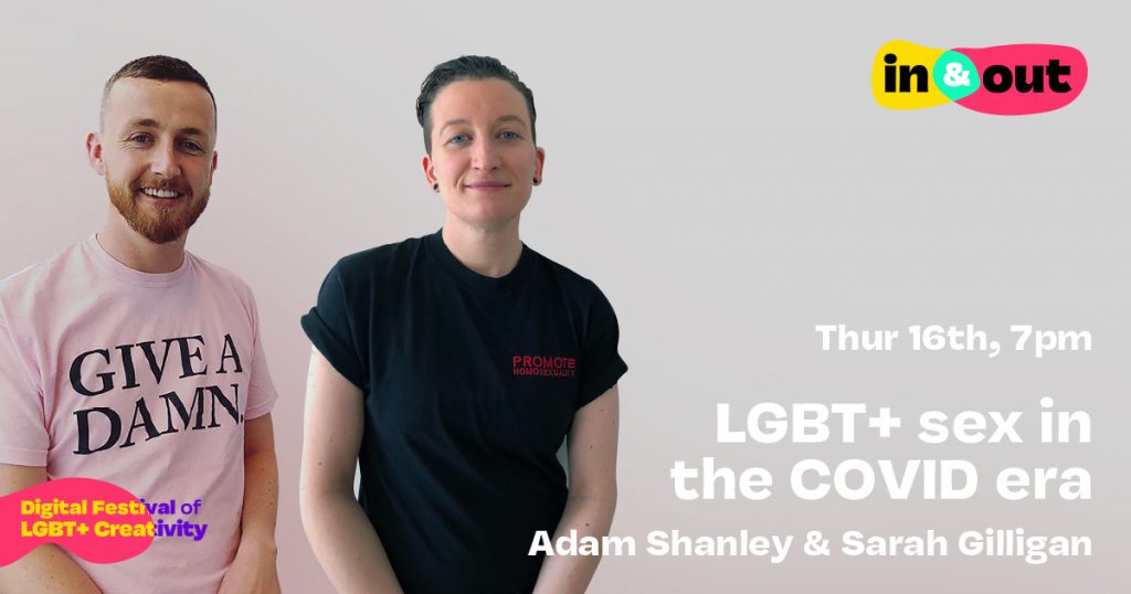 A bearded smiling man and a woman with with tight cropped hair stand in front of a plain background