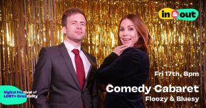 A smirking man in a suit and a smiling woman in velvet pose before a gold tinselled backdrop