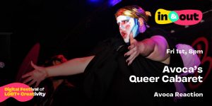 A drag entity with bright paints on their face extends their arms out to an audience