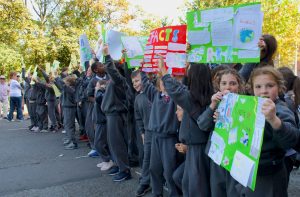 A group of very young schoolchildren holding homemade signs to protest climate change
