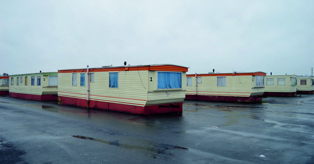 A bleak photo of a row of caravan dwellings at a direct provision centre