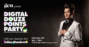 A drag king with slicked back hair and a white tuxedo stands against dark background
