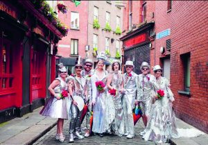 A group of friends in fancy dress wearing silver clothes pose on a Dublin Street