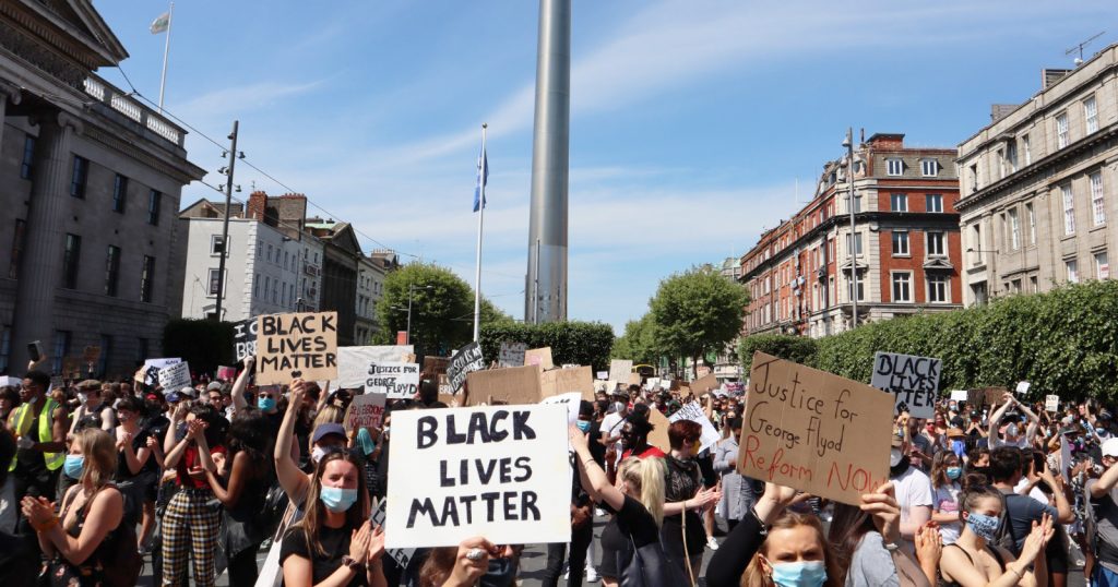 People marching in Dublin while holding signs at the #BlackLivesMatter protest