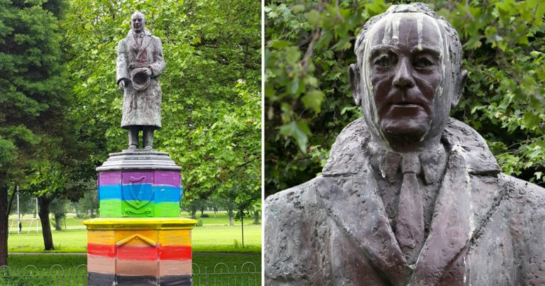 Statue of Sean Russell in a park, the base painted in rainbow colours