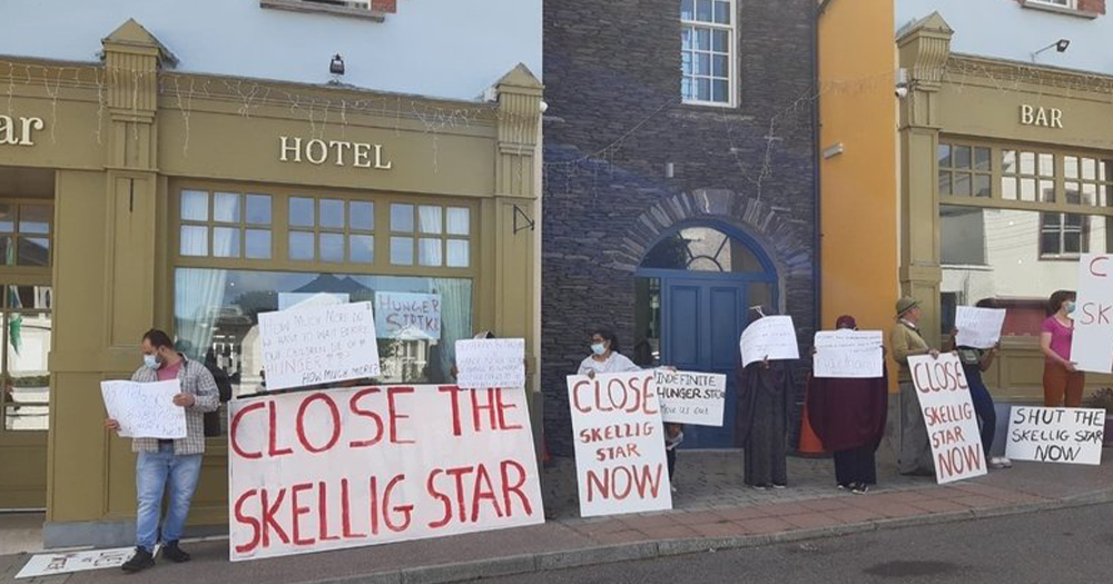 A protest outside a Direct Provision centre in Kerry with people on the street holding banners