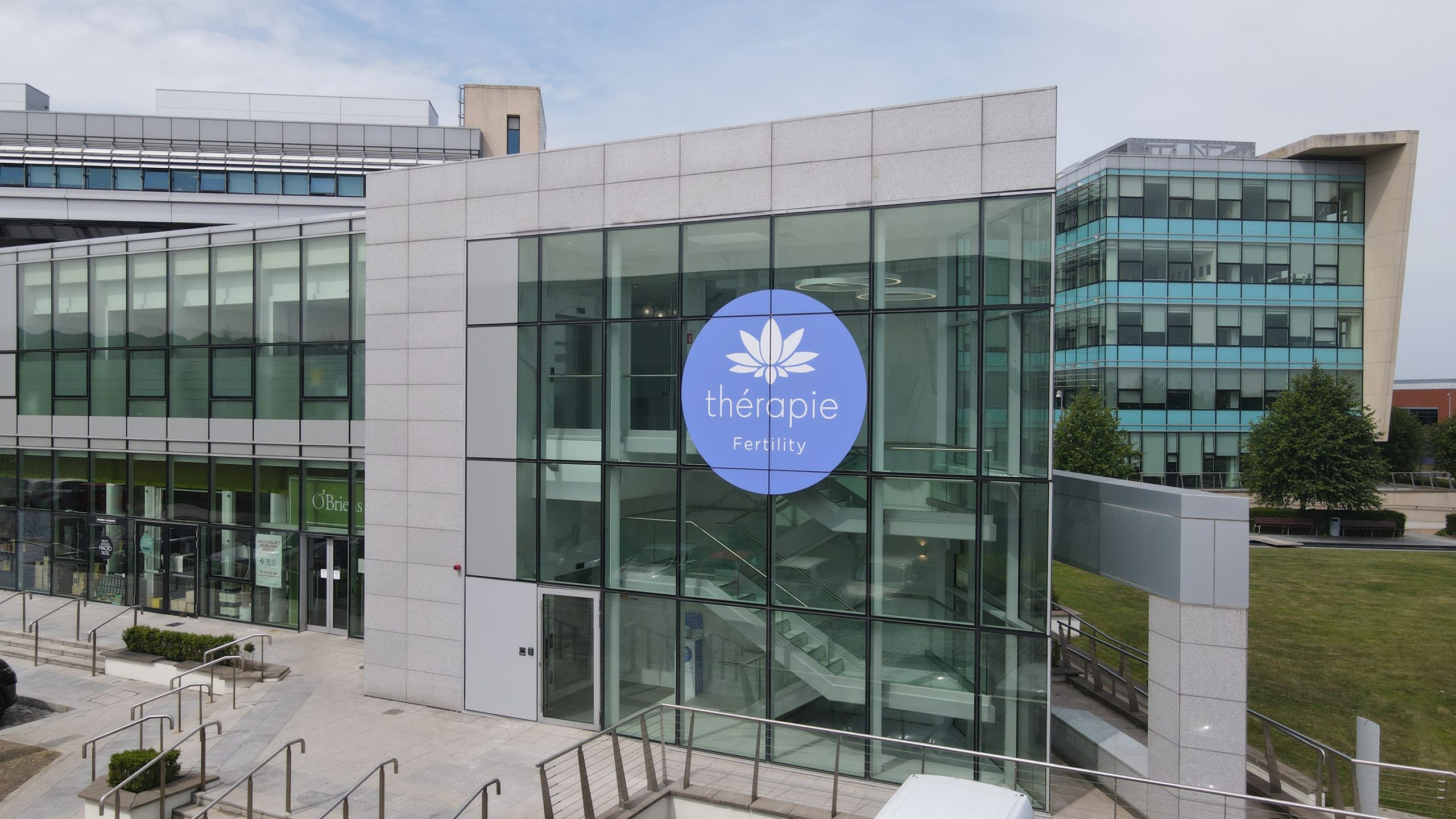 Thérapie Fertility clinic is a class window building on a campus of other buildings.