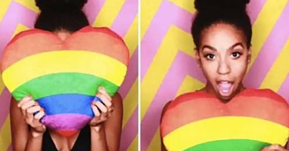 Pearl Mackie holds a Pride pillow over her face