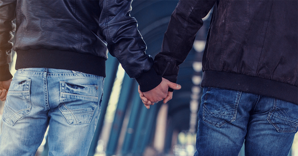 Two men holding hands on the street