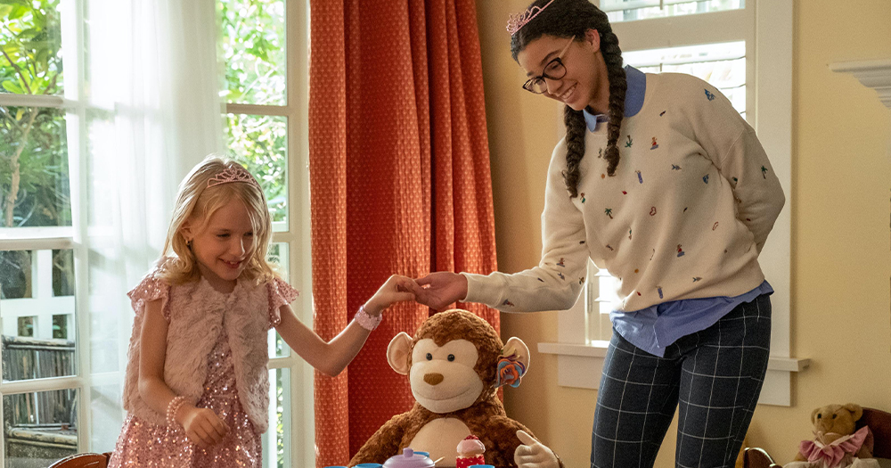 A little girl and her teenage babysitter have a tea party