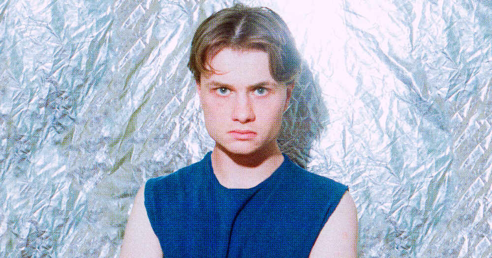PureGrand man looks at camera wearing navy tank top with a silver background