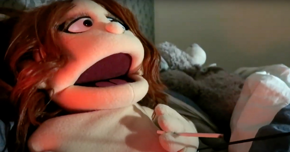A puppet lying down smoking a cigarette