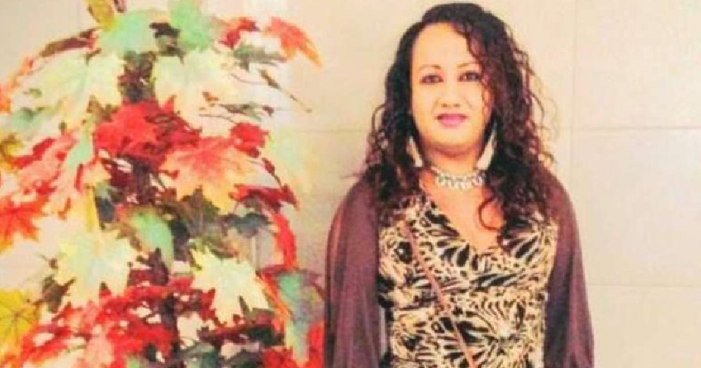 Trans woman from El Salvador, Camila Díaz Córdova, standing beside colourful leaves and smiling, she was murdered last year by three police officers