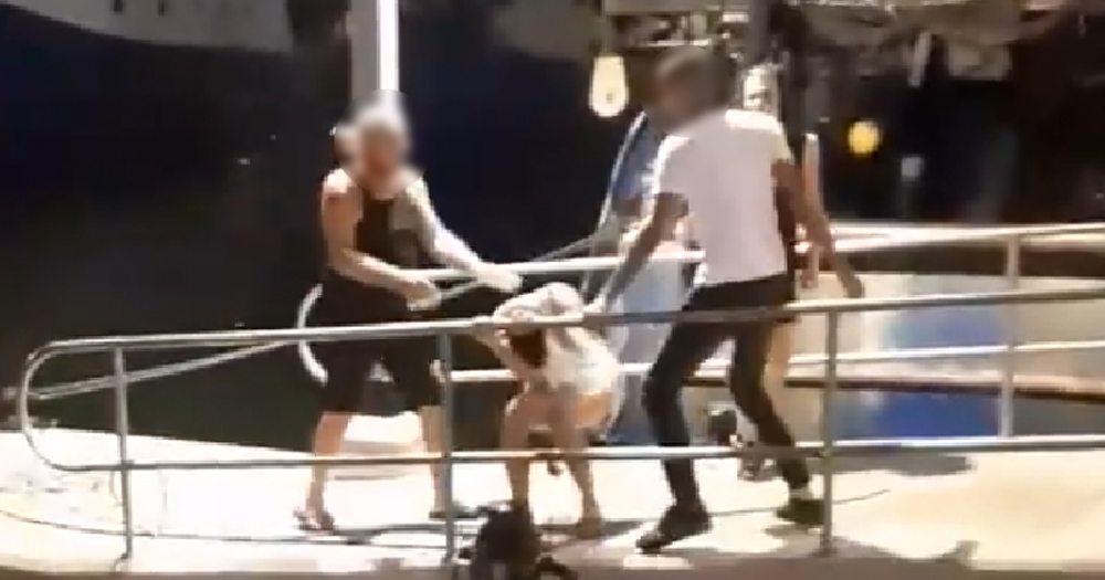 man tries to protect other man from being attacked by man at Jaffa Port in Israel